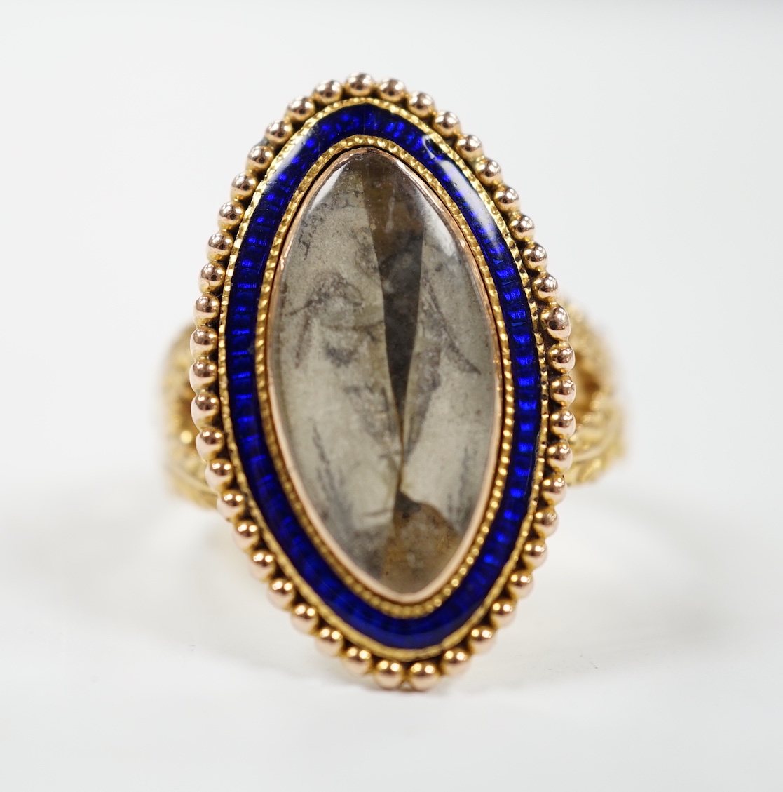 A 19th century 15ct and blue enamel set navette shaped mourning ring, with damaged inset ivory panel, size O, gross weight 5.5 grams. Submission reference Q8ZGC6ZR